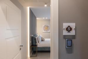 um corredor com um quarto com uma cama e um controlo remoto em Il Pumo - Apulian Rooms Bari Savoia em Bari