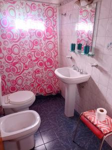 y baño con 2 aseos, lavamanos y espejo. en Departamento Ámbar en Godoy Cruz en Godoy Cruz