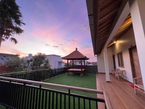 een balkon van een huis met een tuinhuisje bij Nay's Homestay in Canggu