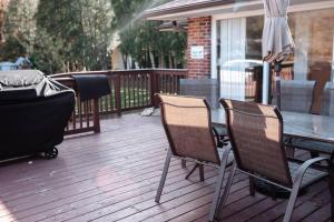 een tafel en stoelen op een terras met een grill bij Spacious Five-Bedroom Bliss in Fairlawn