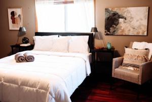 een slaapkamer met een groot wit bed en een stoel bij Spacious Five-Bedroom Bliss in Fairlawn