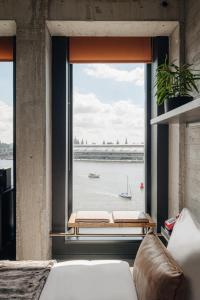 a room with a large window with a view of the water at Sir Adam Hotel, part of Sircle Collection in Amsterdam