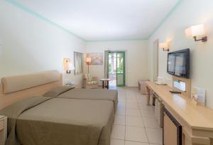 a hotel room with a bed and a television at Silva Beach Hotel in Hersonissos