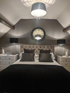 um quarto com uma cama grande e um espelho grande em The Keepers Arms em Quenington