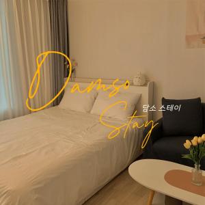 a bedroom with a bed with a sign saying always stay at Damso stay in Seoul