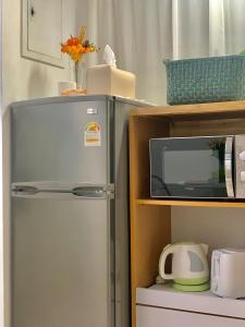 a refrigerator and a microwave on a shelf at Damso stay in Seoul