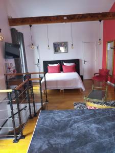 a bedroom with a bed with red pillows at PARIS de FLORE Flore in Malakoff