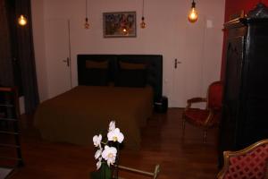 a bedroom with a bed and a table with flowers at PARIS de FLORE Flore in Malakoff