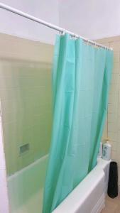 een badkamer met een blauw douchegordijn naast een bad bij sunny house2 in Covina