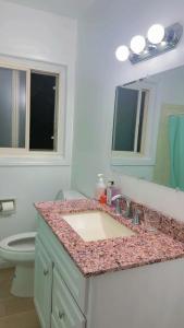 een badkamer met een wastafel, een toilet en een spiegel bij sunny house2 in Covina