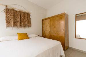 a bedroom with a white bed and a wooden cabinet at Bahía Sirenas in Puerto Escondido +43 photos