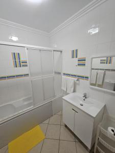 ein weißes Badezimmer mit einem Waschbecken und einem Spiegel in der Unterkunft Hotel Adelaide in Faro