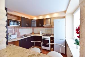 a kitchen with brown cabinets and white appliances at Holiday Apartments with loggia in Druskininkai in Druskininkai