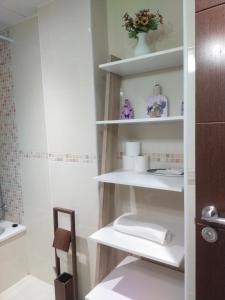 La salle de bains est pourvue d'étagères blanches et de toilettes. dans l'établissement CENTRO ANTEQUERA Moderno Apartamento de Santa Cruz, à Antequera 21 autres photos