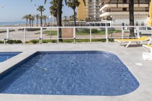 a swimming pool on a patio with a view of the ocean at Florazar 3, 3-C in Cullera