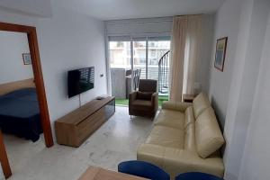uma sala de estar com um sofá e uma televisão em Bravaholidays-298-Central Park em Blanes