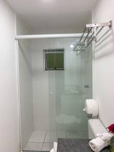 a shower with a glass door in a bathroom at Pousada Rosa in Praia do Rosa