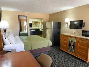 a hotel room with a bed and a refrigerator at Studio 6 Suites North Richland Hills TX in North Richland Hills