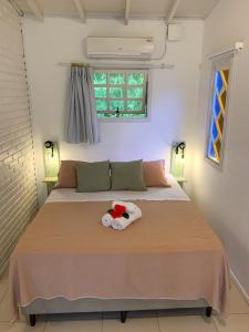 una camera da letto con un letto con un giocattolo sopra di Pousada Rosa a Praia do Rosa
