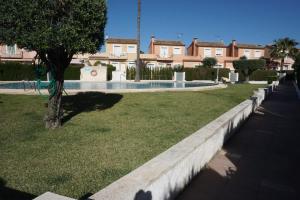 埃爾斯波夫萊特斯的住宿－Casa del Sol in Els Poblets，一座位于庭院的游泳池,庭院里种着树,设有房屋