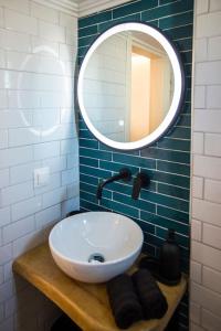 een badkamer met een witte wastafel en een spiegel bij Wanderer, Nilie Hospitality MGMT in Thessaloniki