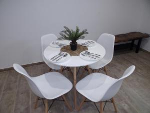 uma mesa branca com cadeiras brancas e um vaso de plantas em Apartamento Buen Dia airport Malaga- playa-Torremolinos em Málaga