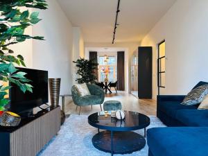 uma sala de estar com um sofá azul e uma mesa em Sofia's Mansion em Breda