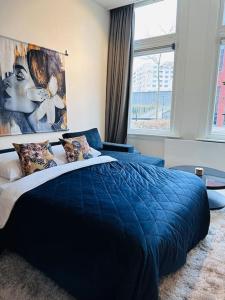 a bedroom with a blue bed and a large window at Sofia's Mansion in Breda