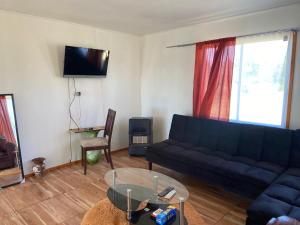 a living room with a blue couch and a glass table at cabañas san antonio in Los Ángeles