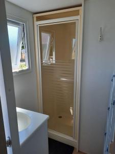 a bathroom with a shower and a sink at LE RHUYS, mobil home cosy proche des plages in Sarzeau
