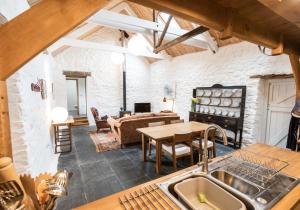 una cucina e un soggiorno con lavandino e tavolo di Ysgubor - Tranquil space for two a Saint Dogmaels Altre 9 foto