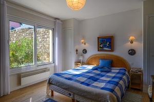 a bedroom with a bed and a large window at Villa Les Pieds Dans L'eau in Loctudy