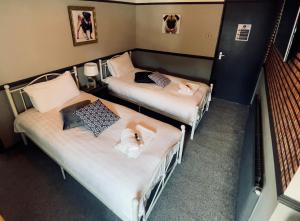 two twin beds in a room at THE ITALIAN GREYHOUND in Great Glen