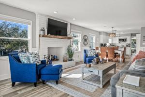 a living room with blue chairs and a fireplace at Coastal Gem of Murrells Inlet in Myrtle Beach