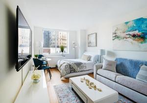 - un salon avec un canapé et une table dans l'établissement Modern Studio Apartment At East Side, à New York