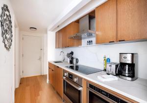 - une cuisine avec des placards en bois et une cuisinière dans l'établissement Modern Studio Apartment At East Side, à New York