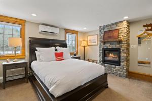 um quarto com uma cama e uma lareira em Brook Bound Inn em Wilmington
