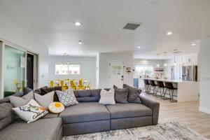 uma sala de estar com um sofá cinzento e uma cozinha em Modern Palm Springs Home with Pool and Gas Fire Pit! em Palm Springs