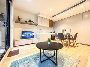 uma cozinha e sala de estar com uma mesa e uma televisão em Beautiful City View 2br1ba In Melbourne Cbdwifi em Melbourne