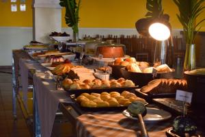 a buffet line with various types of bread and pastries at Valen Porto Hotel São Luís in São Luís