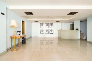 a large white room with a table and a lamp at Wish Inn Chidlom - CentlralWorld By GO INN in Makkasan