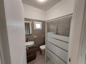 uma casa de banho com um WC e um lavatório em ApartmentsGarda - Velia 23 em Lazise