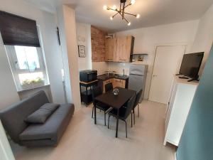 uma sala de estar com um sofá, uma mesa e uma cozinha em ApartmentsGarda - Velia 23 em Lazise