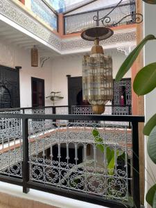 a balcony with a chandelier and a room at Riad Hugo in Marrakesh