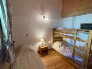 een slaapkamer met twee stapelbedden en een lamp bij Superbe Duplex 4 pièces avec garage, 2 salles de bains, proche télécabine, WiFi - FR-1-293-89 in Villard-sur-Doron +10 foto's