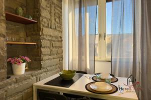a kitchen with a table with two plates on it at Beaches 1 min away - Free WiFi - Smart TV - AC in Albisola Superiore