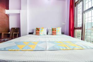 1 dormitorio con 1 cama grande y almohadas coloridas en Flagship The Alpine Homes en Solan