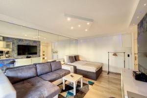 een woonkamer met een bank en een tafel bij HENRI CAMILLE REAL ESTATE -LOUIS - Studio premium city center in Cannes