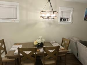 a dining room with a wooden table and a chandelier at Cozy Living in Surrey