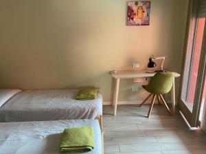 Habitación con 2 camas y escritorio con silla. en Lisonino House, en SantʼAngelo Lodigiano